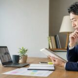 英語会議の前に資料と表現を準備する社会人