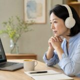 ヘッドホンを着けて英語動画を静かに聴く意図的清聴中の社会人女性