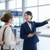外国人旅行者へ英語で案内する日本人航空会社スタッフ