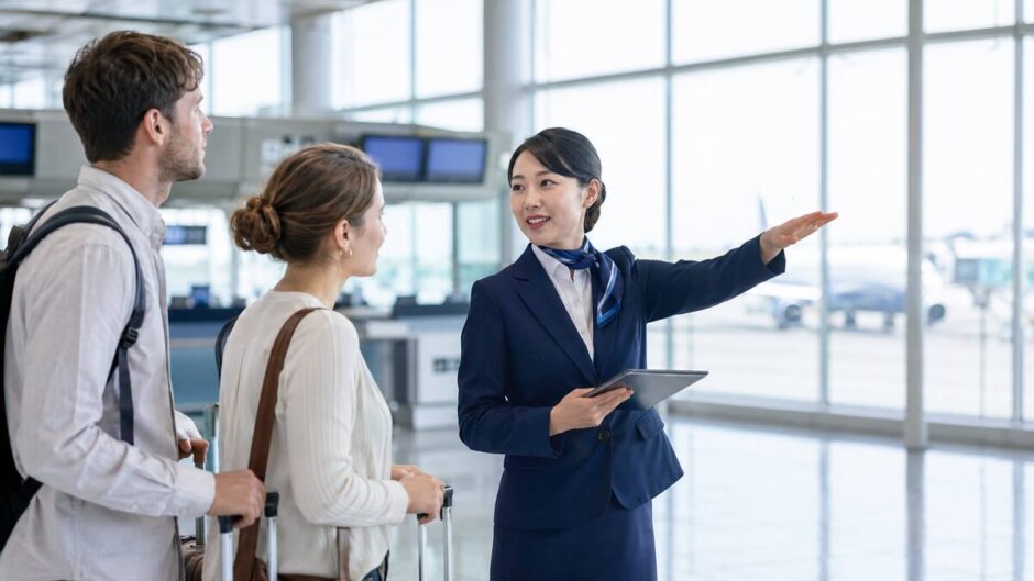 外国人旅行者へ英語で案内する日本人航空会社スタッフ