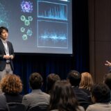 国際学会で海外の研究者から質問を受ける日本人研究者